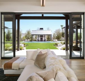 black multislide door opening up to large backyard with pool