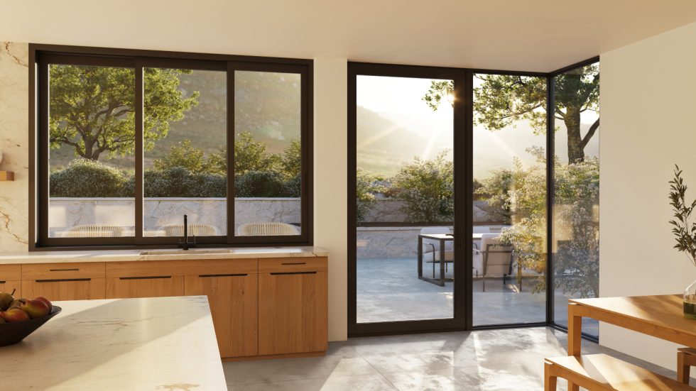 Bright kitchen with sleek aluminum doors opening to a sunny, inviting outdoor seating area
