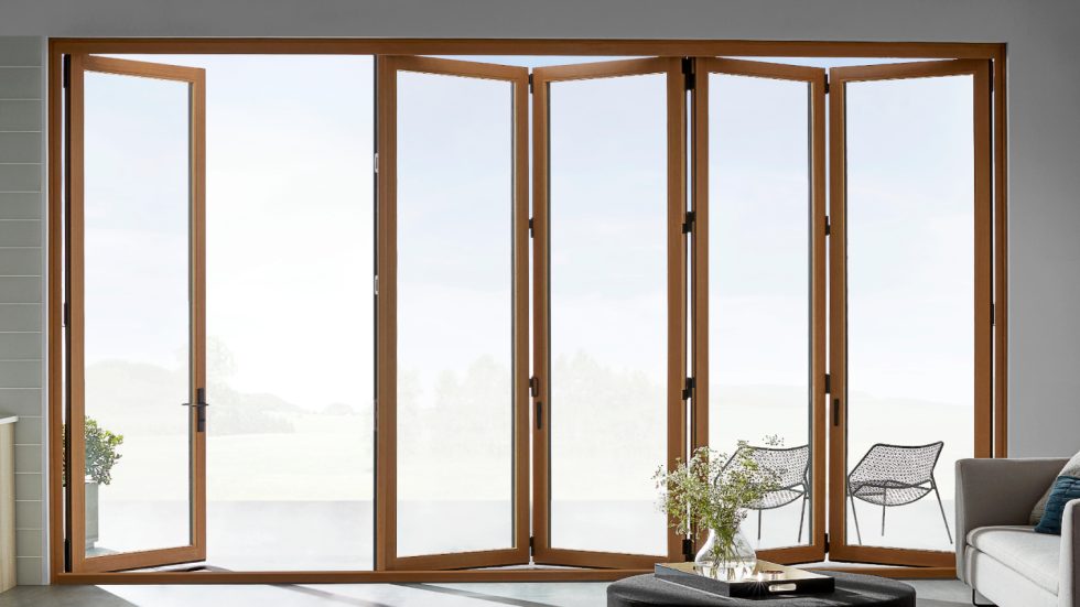 Bright living space with folding wood doors opening to tranquil outdoor seating area