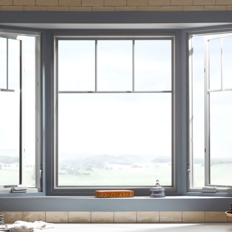 Bright bay window with open panes inviting natural light into a cozy, welcoming space