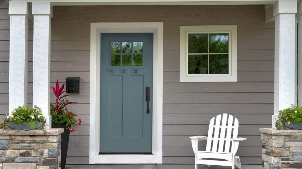 Welcoming front porch with a sturdy fiberglass door, cozy chair, and vibrant plants.