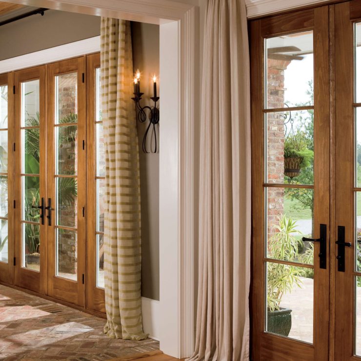 Warm natural light fills a welcoming home through elegant wood-framed French doors.