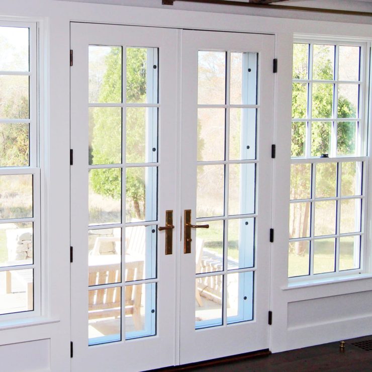Bright room with white framed patio doors and windows opening to a peaceful outdoor space