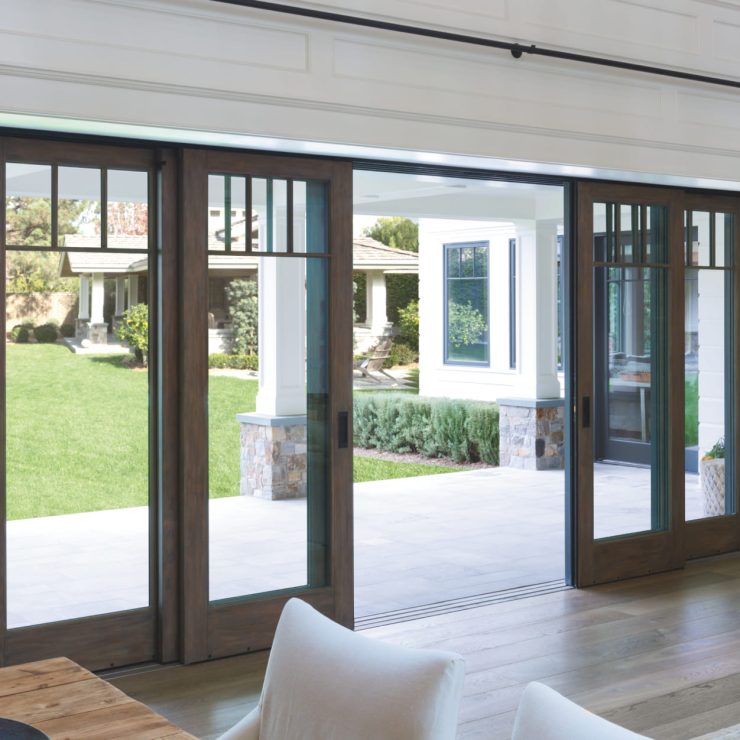 Spacious living area with wood sliding doors opening to a bright, green backyard retreat.