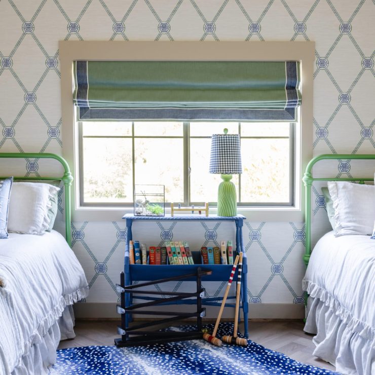 Cozy bedroom with twin beds, playful pups, and a bright sliding window with soft natural light.