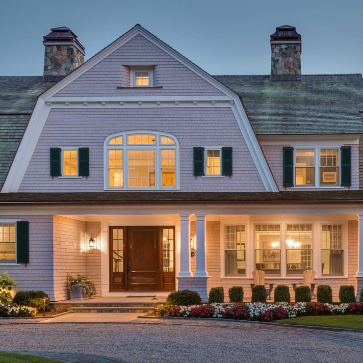 Warm-lit traditional home showcasing elegant windows and doors, inviting comfort and connection.