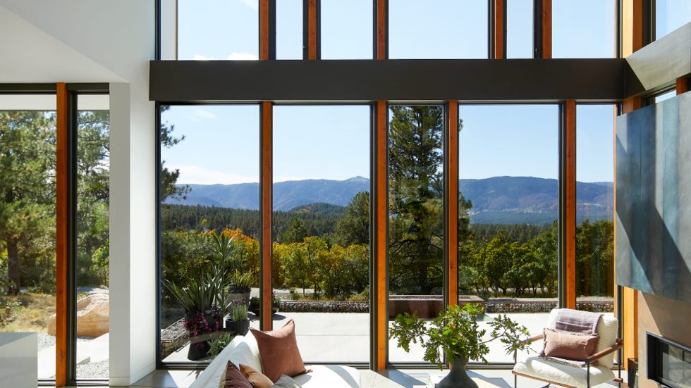 Spacious living area with floor-to-ceiling windows opening to a scenic mountain view.